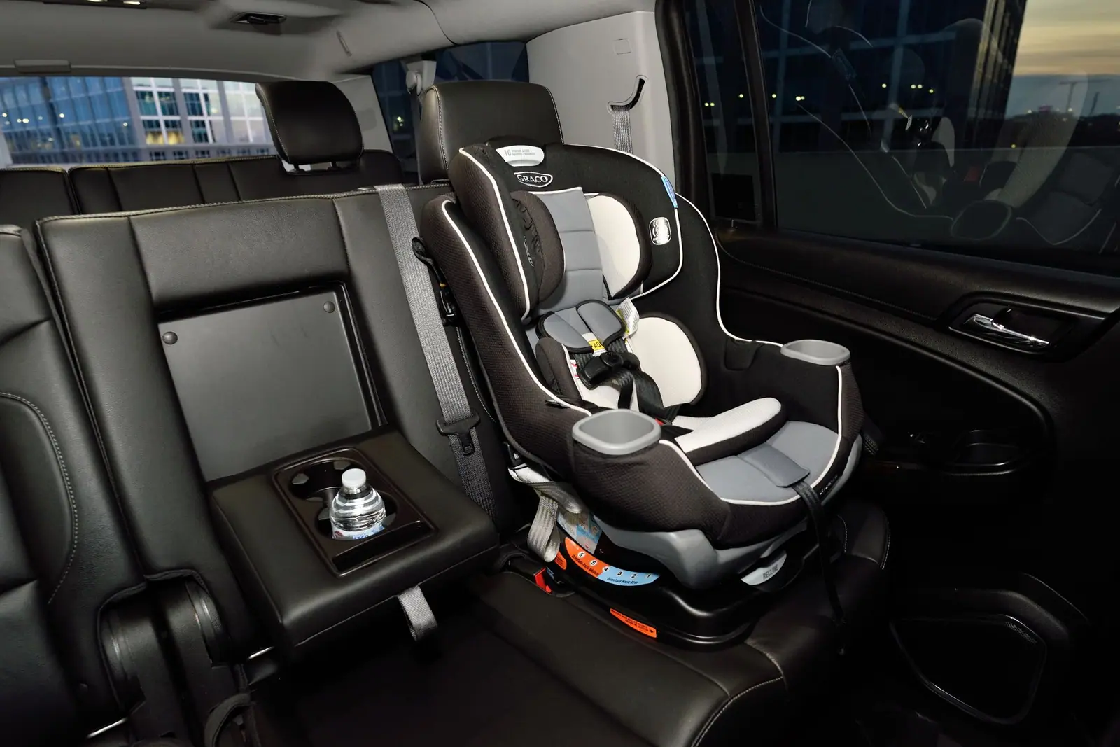 Two child seats installed side by side across a car back seat